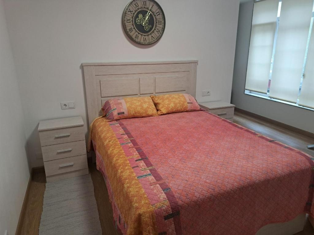 a bedroom with a bed and a clock on the wall at Habitación privada en el mismo Camino de Santiago in Caldas de Reis