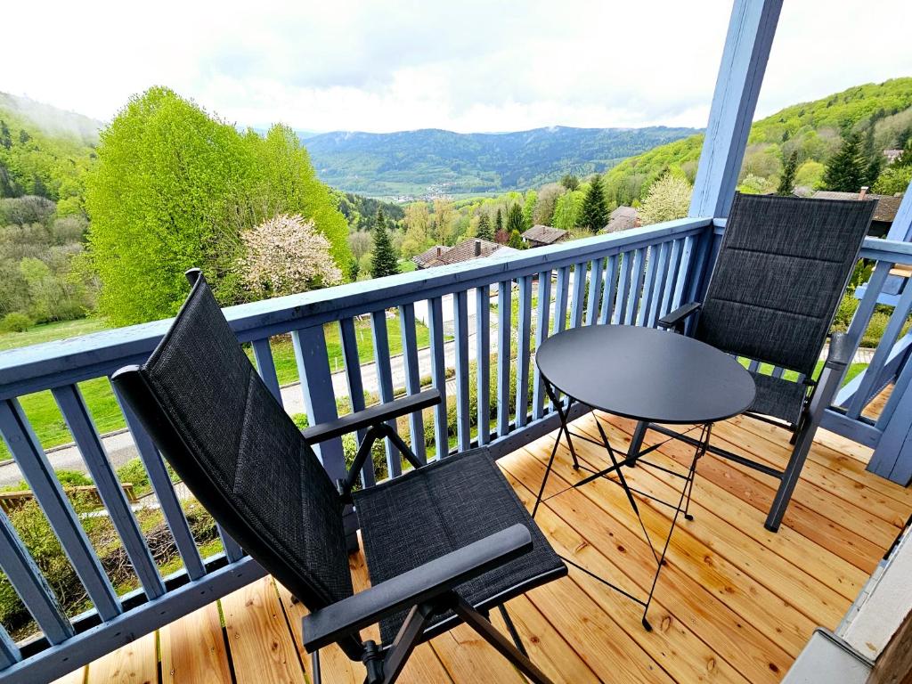 3 sedie e un tavolo sul balcone con vista di "Weitblick" im Ferienland Sonnenwald Weitblick zum Arber a Langfurth 