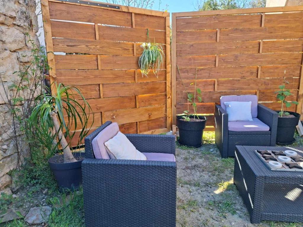 une terrasse avec 2 chaises et une clôture dans l'établissement Location appartement, à Saint-Paul-le-Jeune