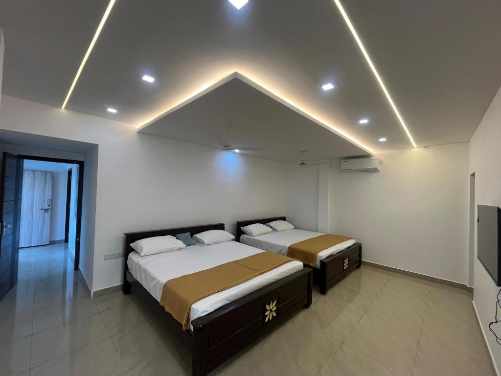 ein Schlafzimmer mit zwei Betten in einem Zimmer in der Unterkunft Sakthi Guest House in Tiruvannāmalai