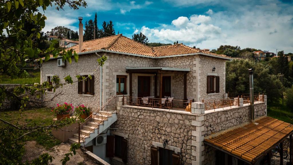 a stone house with a porch and a deck at Katouna Stone House in Katouna