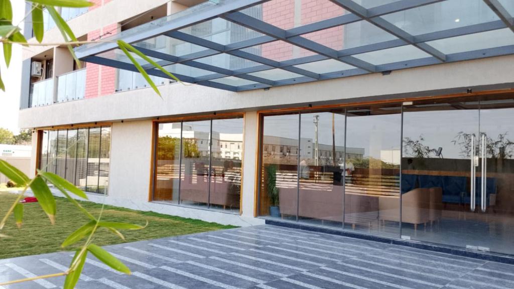 a facade of a building with glass windows at The Blues Hotel in Chharodi