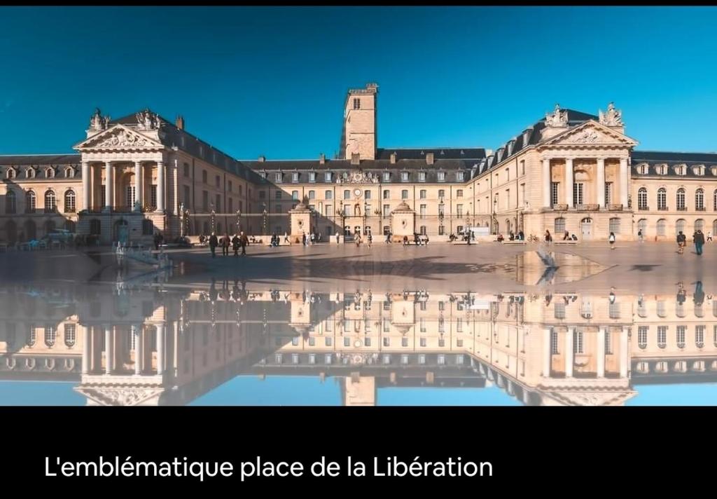 un grand bâtiment avec sa réflexion dans l'eau dans l'établissement Le Courbet Fabulous 1-Bedroom, à Dijon