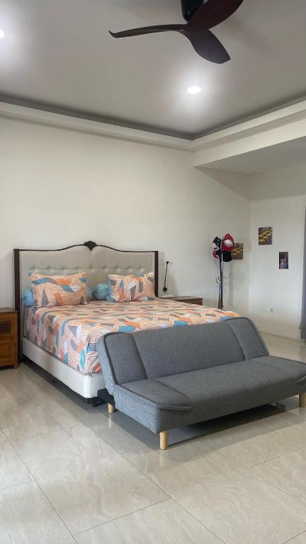 a bedroom with a bed and a ceiling fan at Rumah Malika in Munggu