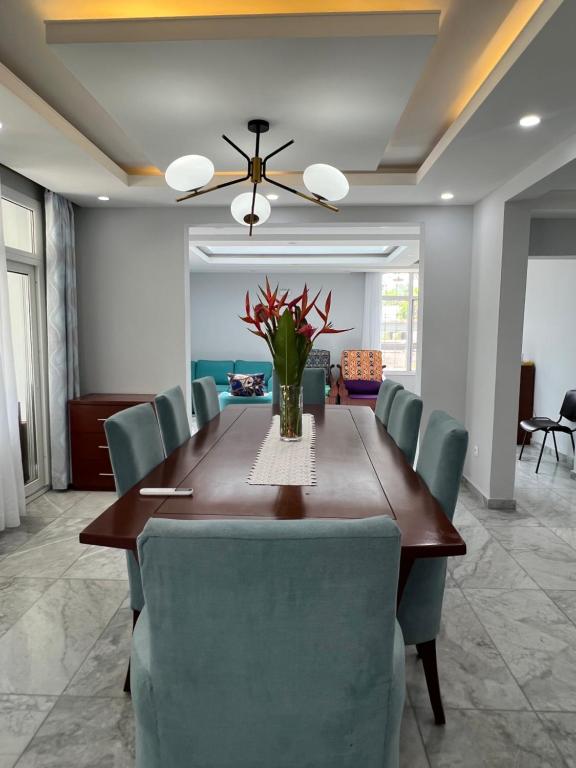 a dining room with a table and blue chairs at La villa des anges in Kribi