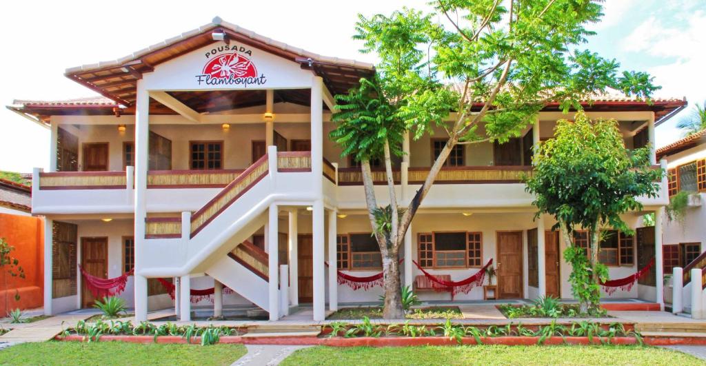 a building in a resort with trees in front of it at Pousada Flamboyant in Arraial d'Ajuda