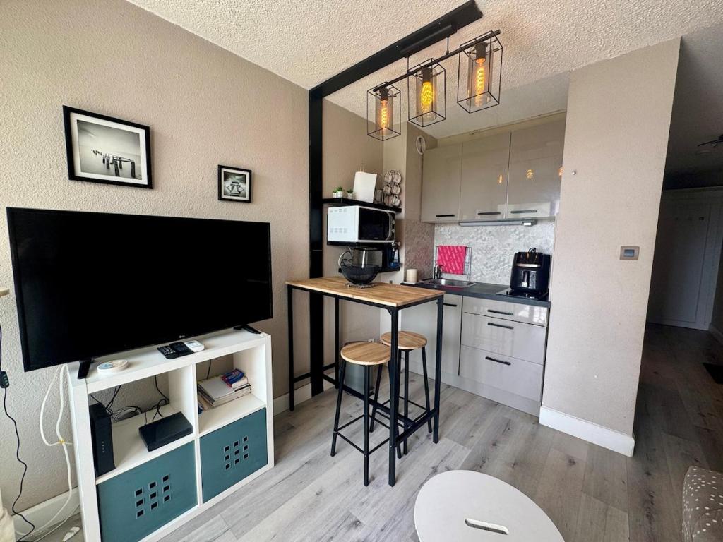 - une cuisine avec une table et une télévision dans la chambre dans l'établissement Appartement - Cap d'Agde, au Cap d'Agde