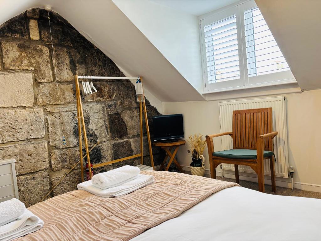 a bedroom with a bed and a stone wall at Foundry Cottage in Portland