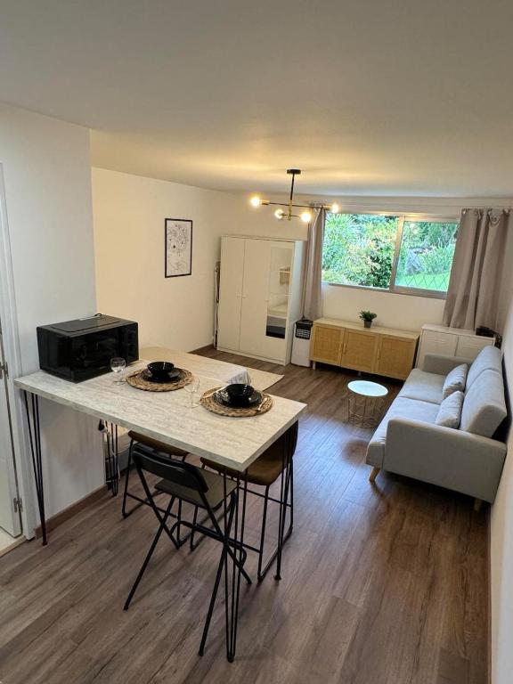 un salon avec une table et un canapé dans l'établissement Studio with swimming pool, à Vallauris