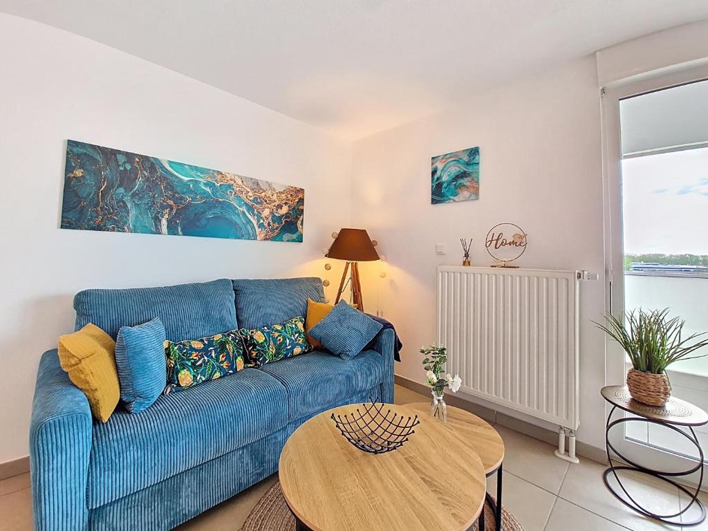 un salon avec un canapé bleu et une table dans l'établissement Chez Lady Mag - Neuf - Confort - Parking - Proche centre-ville - Tram, à Strasbourg