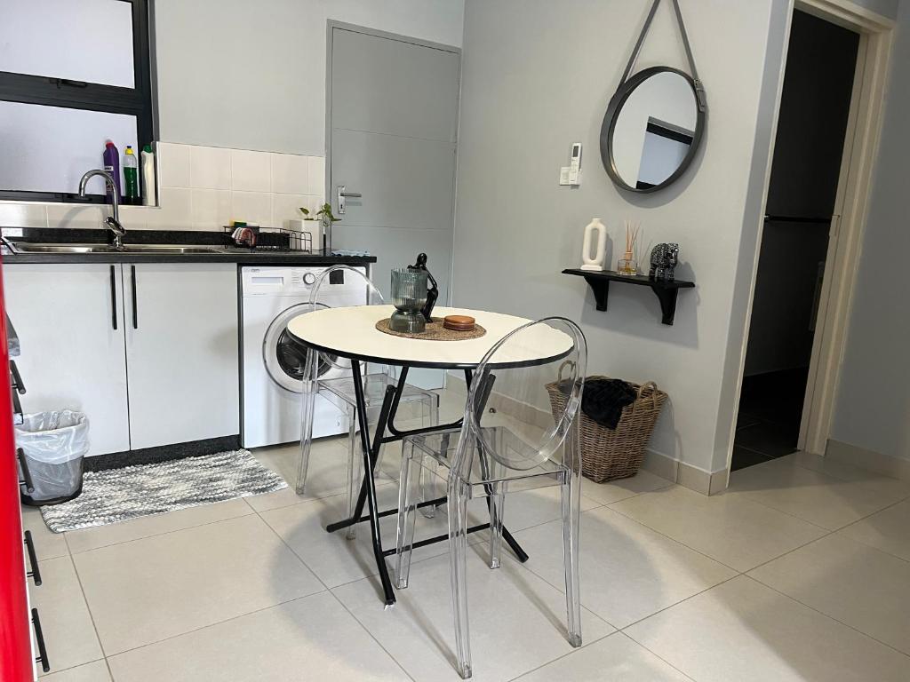 a kitchen with a table and a washing machine at Sarona LoLa A103 Kappa in Gaborone
