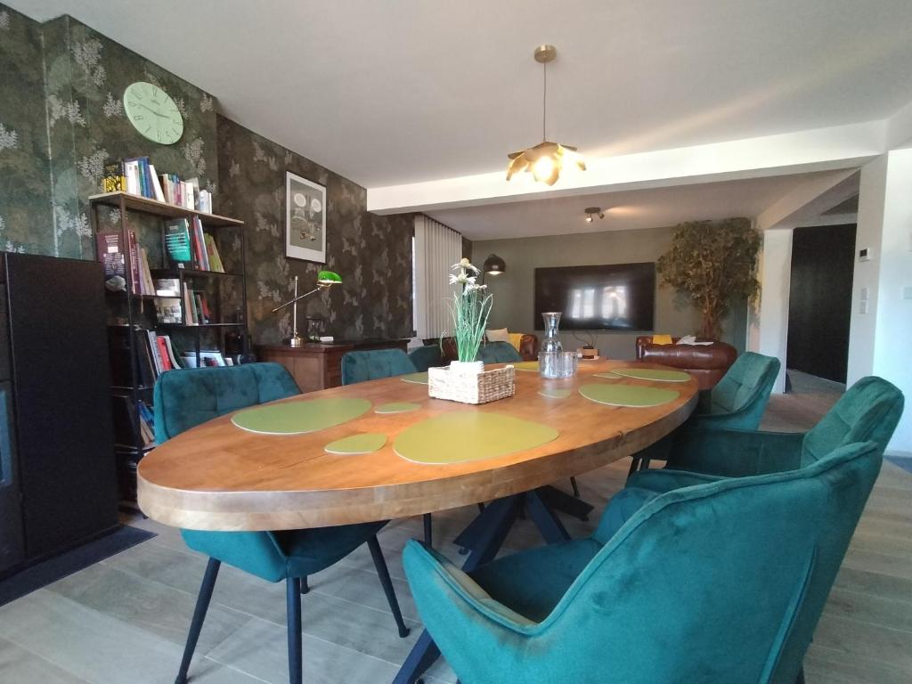 a dining room with a wooden table and blue chairs at Le Duché de Godefroy in Bouillon
