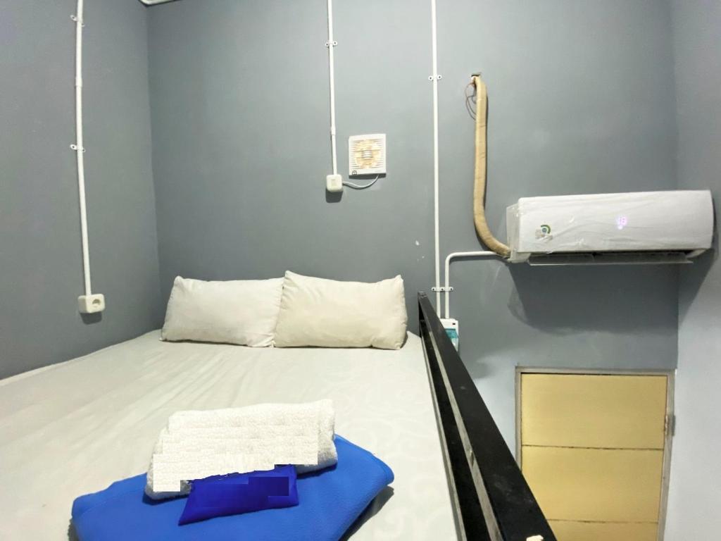 a hospital room with a bed with a towel on it at Helloroom Mampang Jl Bank in Jakarta