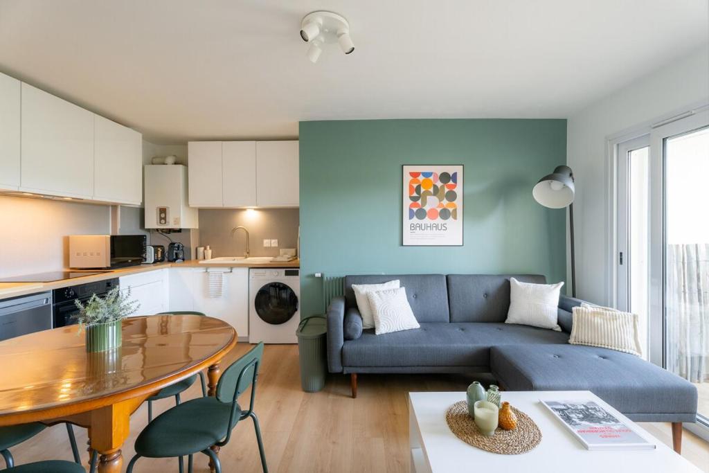 un salon avec un canapé bleu et une table dans l'établissement Les Terrasses de Venetis - parking for 3 people, à Vannes