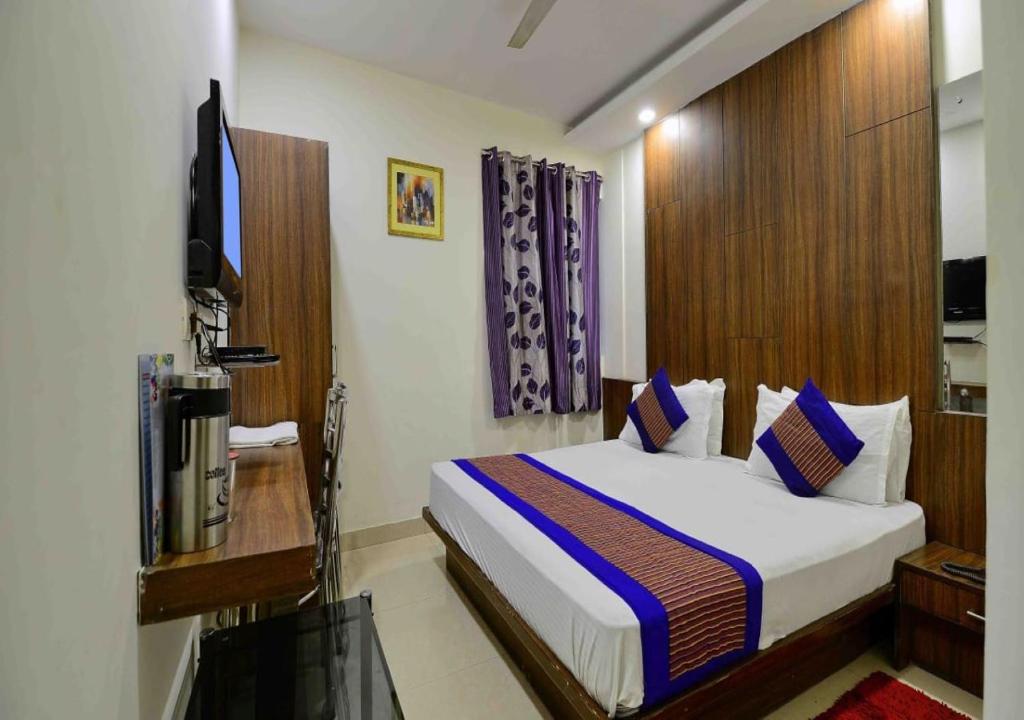 una camera d'albergo con un letto e una televisione di Hotel SPOT By A1Rooms- Walking The Station and Metro Station a Nuova Delhi