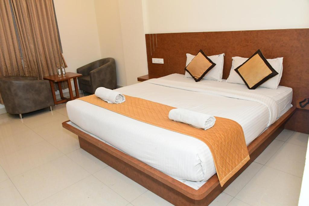 Postel nebo postele na pokoji v ubytování Sai Vihaar Inn & Suites