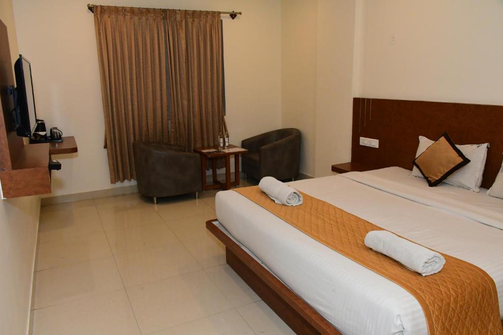 Postel nebo postele na pokoji v ubytování Sai Vihaar Inn & Suites