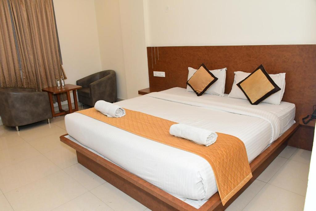 Postel nebo postele na pokoji v ubytování Sai Vihaar Inn & Suites