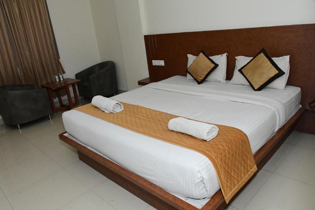 Postel nebo postele na pokoji v ubytování Sai Vihaar Inn & Suites