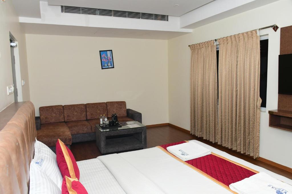 Postel nebo postele na pokoji v ubytování Sai Vihaar Inn & Suites