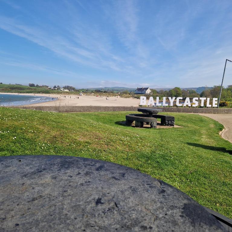 a park with a bench on the beach at Beach View Ballycastle Escape in Ballycastle