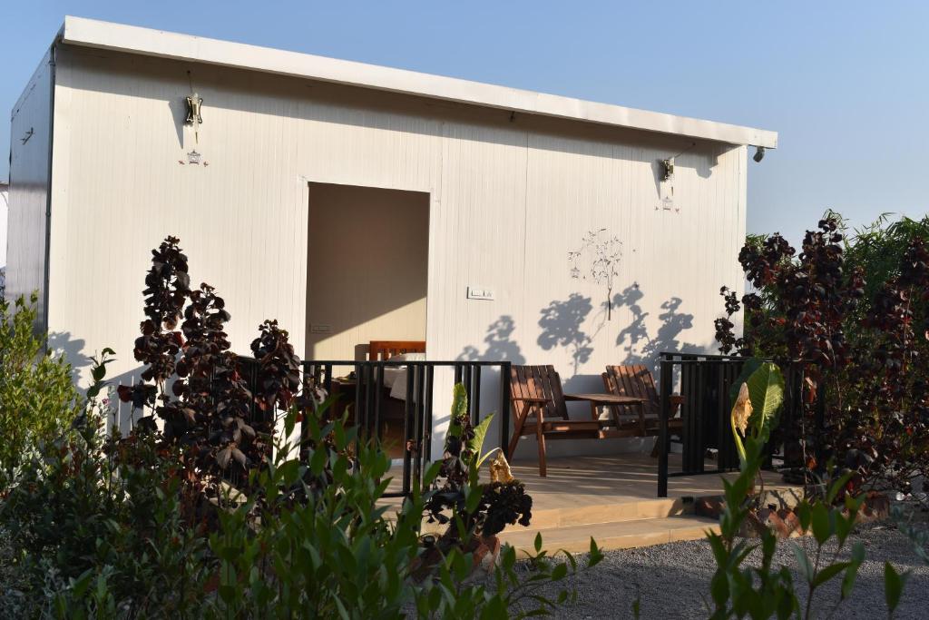 a small white house with a porch at Elk Seizon Retreat in Kundakal
