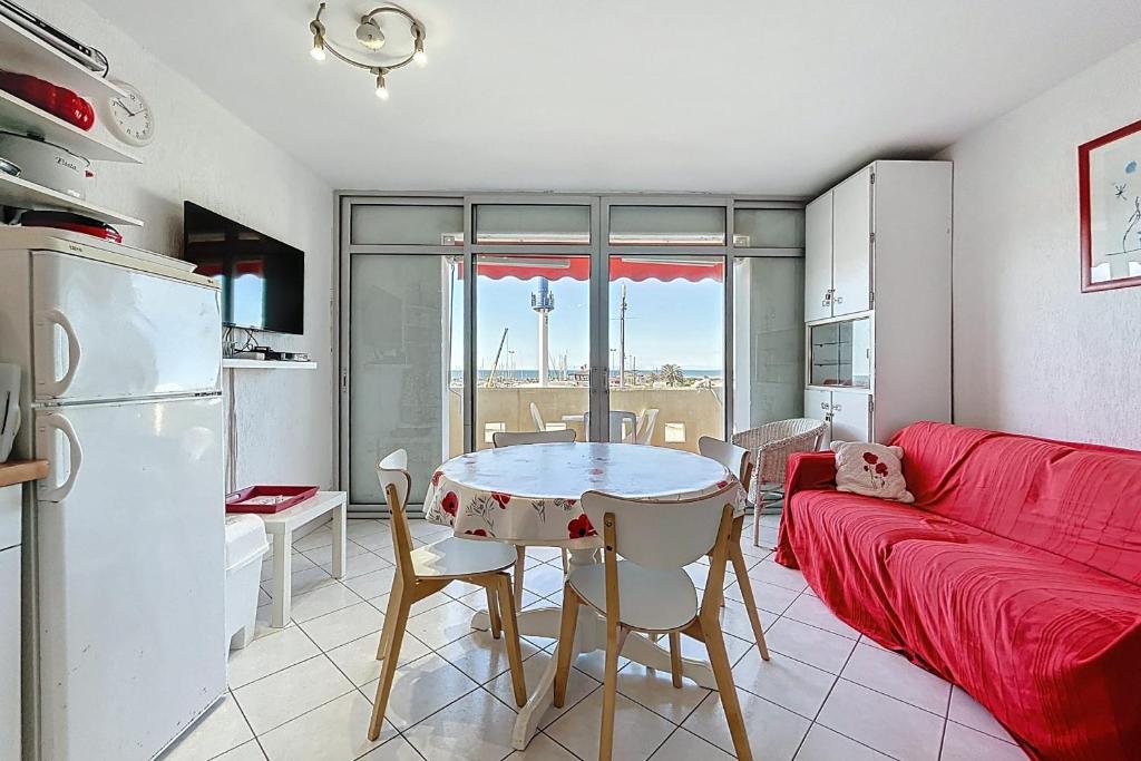 un salon avec un canapé rouge et une table dans l'établissement Le Rouget - Proche du port et de la mer - Parking, à Fleury