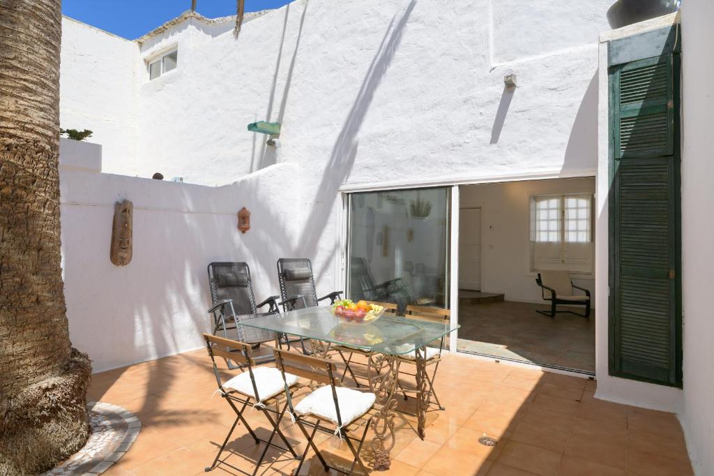 a patio with a glass table and chairs at Casa la Mayor in Costa Teguise