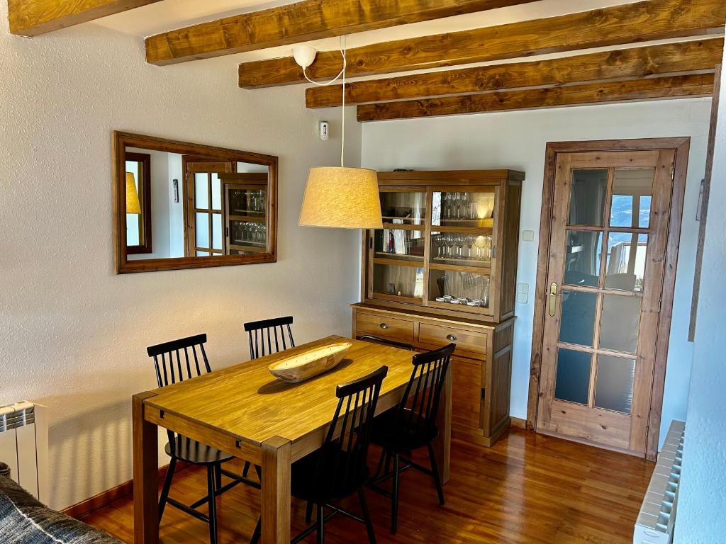 a dining room with a wooden table and chairs at El Mirador d'Olp in Olp