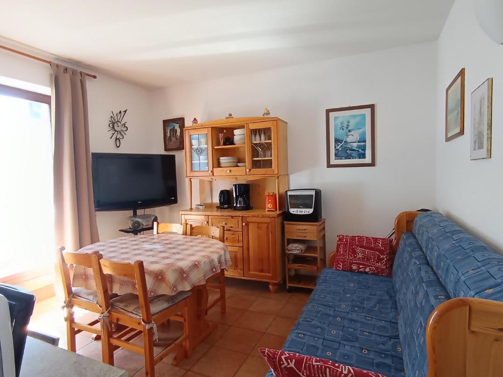 un salon avec un canapé bleu et une télévision dans l'établissement Appartement rénové 2 pièces + coin montagne - 6 pers - Centre village près des pistes - 2* - FR-1-445-119, à Montgenèvre
