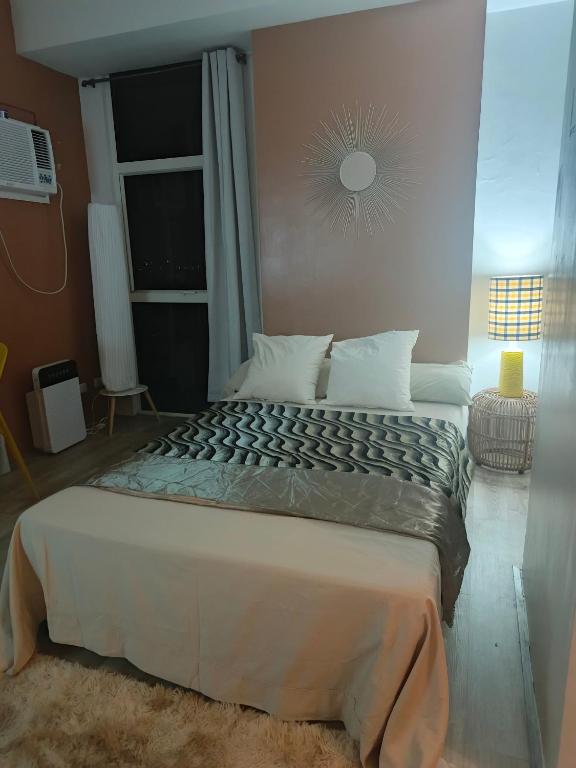 a bedroom with a large bed with a window at Mesavirre Garden Residences Condo Bacolod in Bacolod