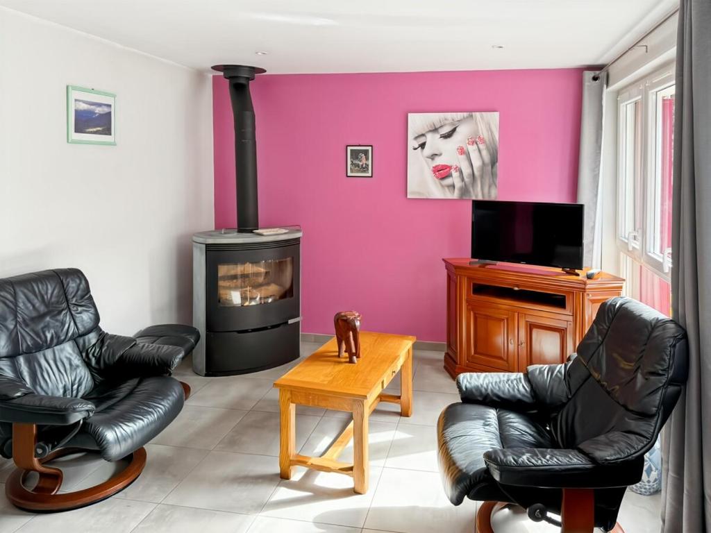 ein Wohnzimmer mit zwei Stühlen und einem Kamin in der Unterkunft Vallée de la Jordanne, Maison cosy 6pers, terrasse in Saint-Julien-de-Jordanne