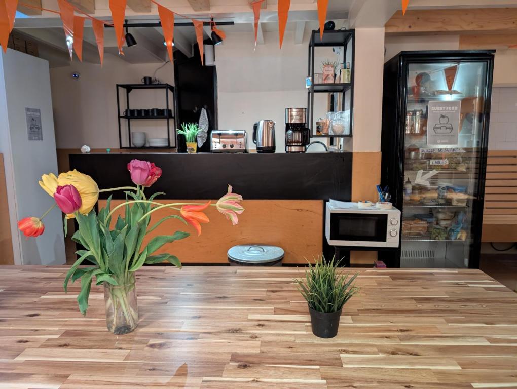 ein Geschäft mit einer Vase mit Blumen auf einem Holzboden in der Unterkunft Onefam Amstel in Amsterdam