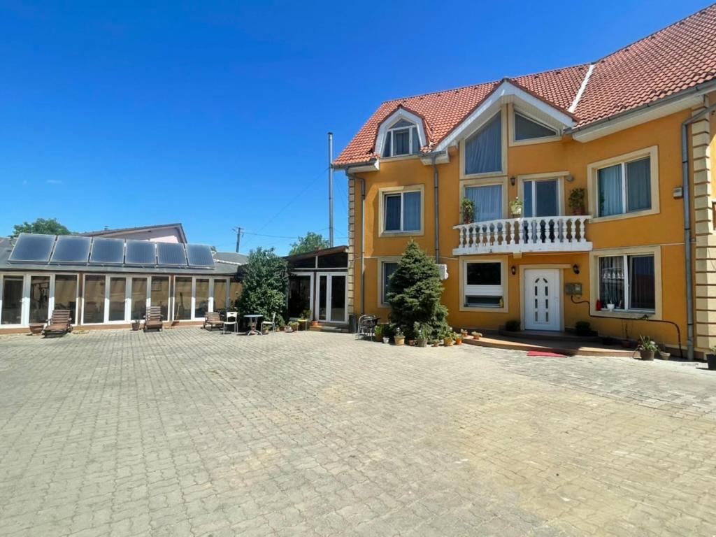 ein großes Gebäude mit einem Innenhof davor in der Unterkunft Pensiunea Lotus Baile 1 Mai in Baile Unu Mai