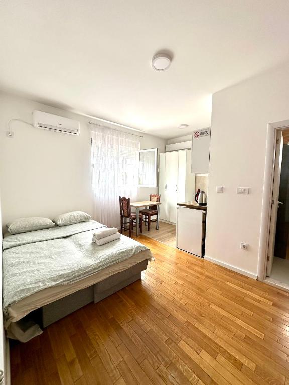 a bedroom with a bed and a wooden floor at Apartment Stex 2 in Podgorica