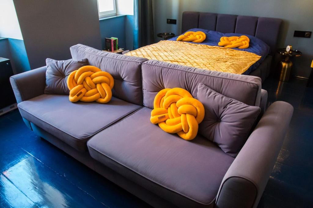a purple couch with orange pillows on top of it at Widok na Starówkę Mona Lisa by Rentoom in Toruń