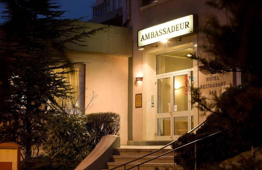 un bâtiment avec une enseigne sur la façade dans l'établissement Les nouveaux Ambassadeurs, à Saint-Chamond