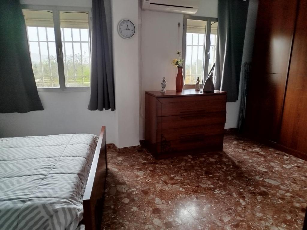 a bedroom with a bed and a dresser and windows at Apartamento acogedor in Seville