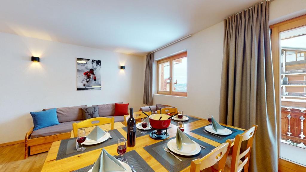 een eetkamer met een tafel en een bank bij Pracondu 2 308 - OUTDOOR & FUN charming apartment in Nendaz