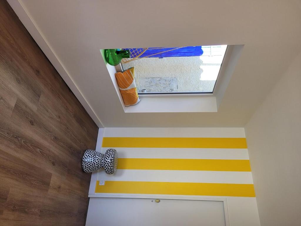 een kamer met gele en witte strepen op het plafond bij Oacys in Le Barcarès