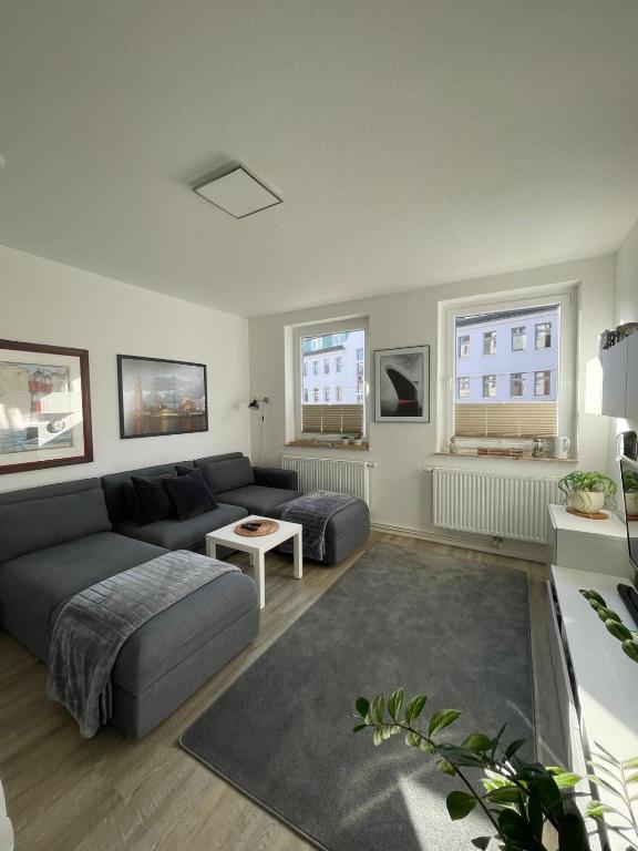 una sala de estar con un sofá y una mesa en Zentrale FeWo Küstenglück nah am Deich, en Bremerhaven