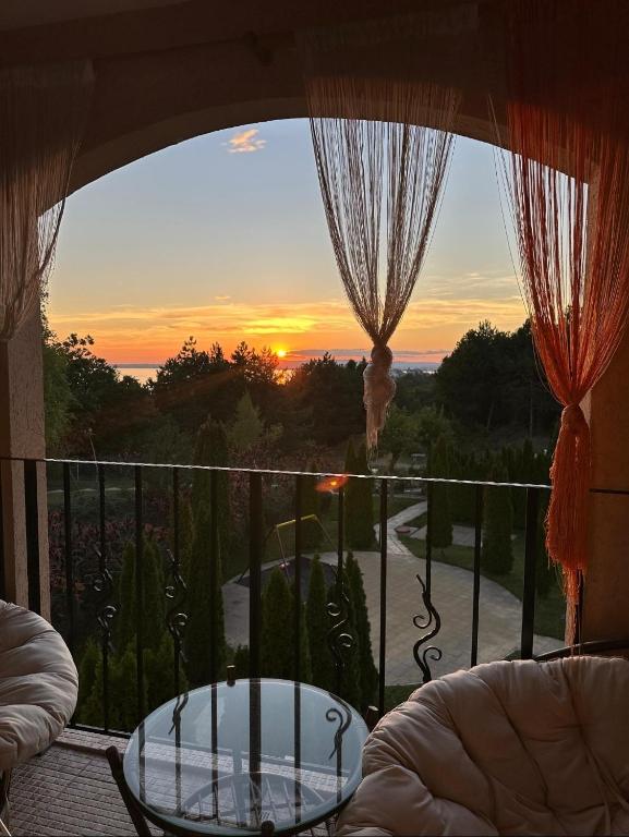 a view of a sunset from a balcony with a table at Golden Lady in Sveti Vlas