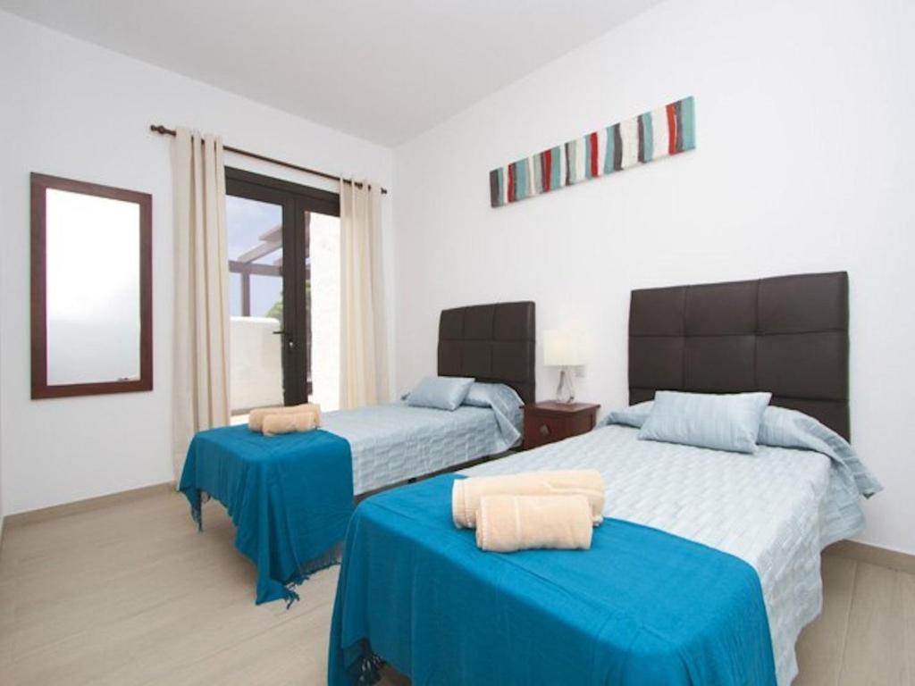 Posteľ alebo postele v izbe v ubytovaní Modern Villa In Los Mojones 4 Bedrooms Large Heated Pool Villa Mojones Puerto Del Carmen