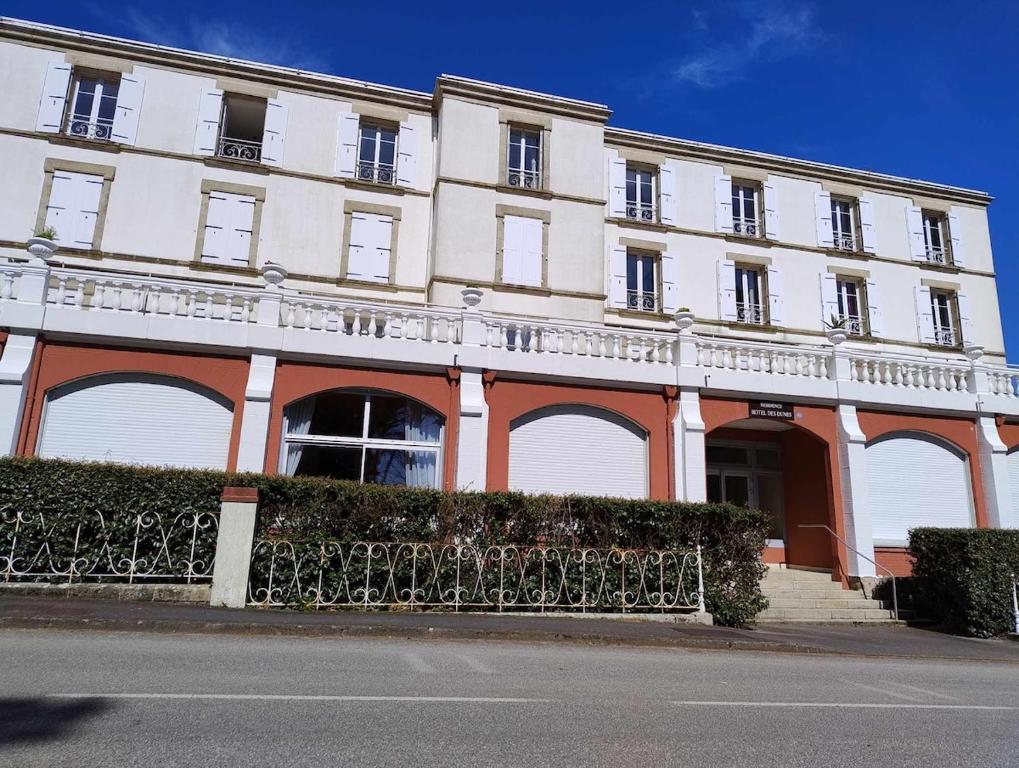 un grand bâtiment blanc et orange dans une rue dans l'établissement Les Dunes Résidence face à la plage des Dunes, à Fouesnant