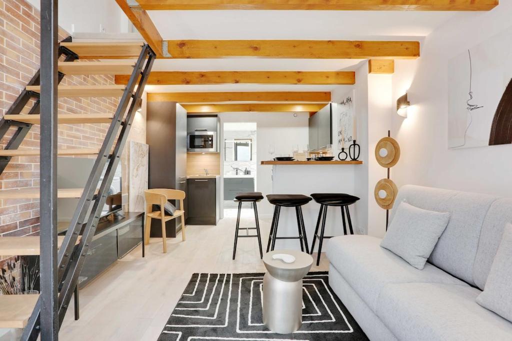 un salon avec un canapé blanc et une cuisine dans l'établissement Duplex Cosy Canal Saint Martin, à Paris