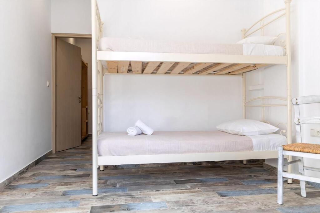 una camera con due letti a castello e un tavolo di Luxury Naxos Suites Superior Quadruple Apartment City Center Modern Furnishing With Private Balcony Saint George a Naxos Chora