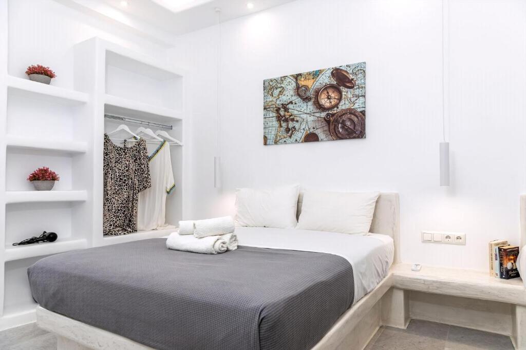 a white bedroom with a large bed and white walls at Superb Naxos Apartment Grand Suite In The Heart Of Town Balcony City Views Saint George in Naxos Chora