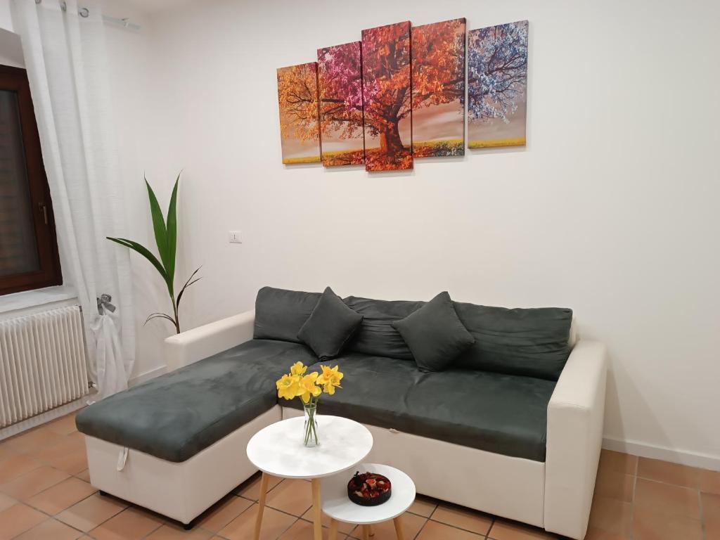 a living room with a couch and paintings on the wall at La Casa Vacanze di Byron in Gorizia