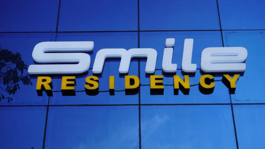 a sign that says smilereery on a wall at Smile Residency in Sultan Bathery