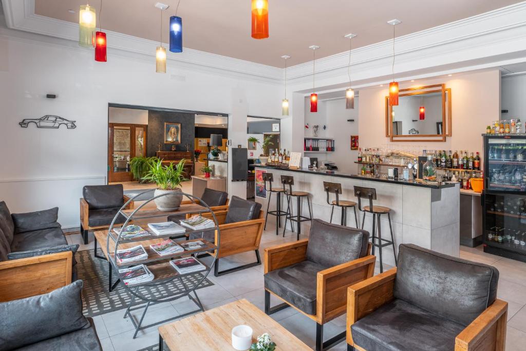a bar in a restaurant with chairs and a counter at Hôtel Vauban Briançon Serre Chevalier in Briançon